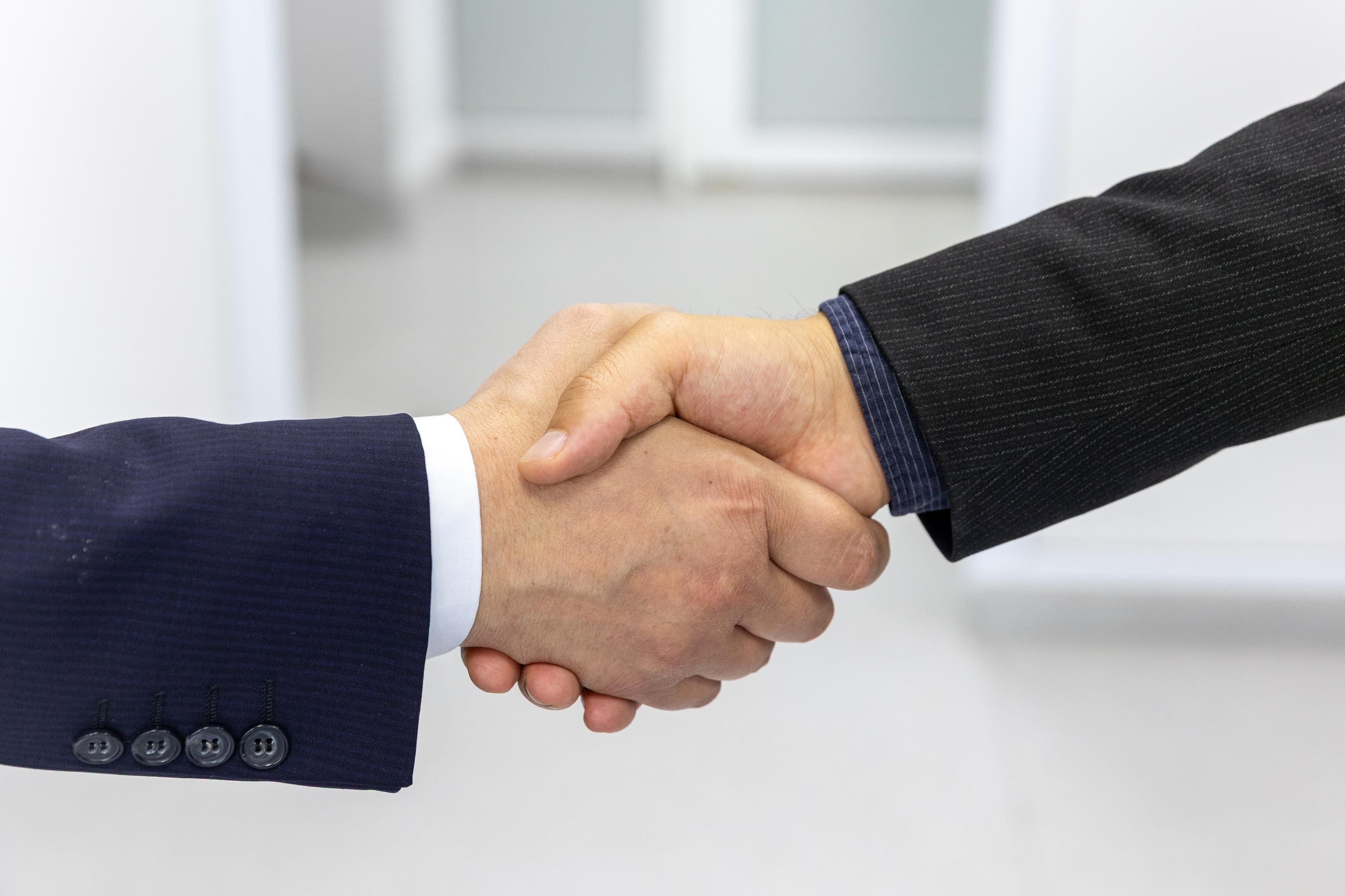 Due persone in giacca che si stringono la mano